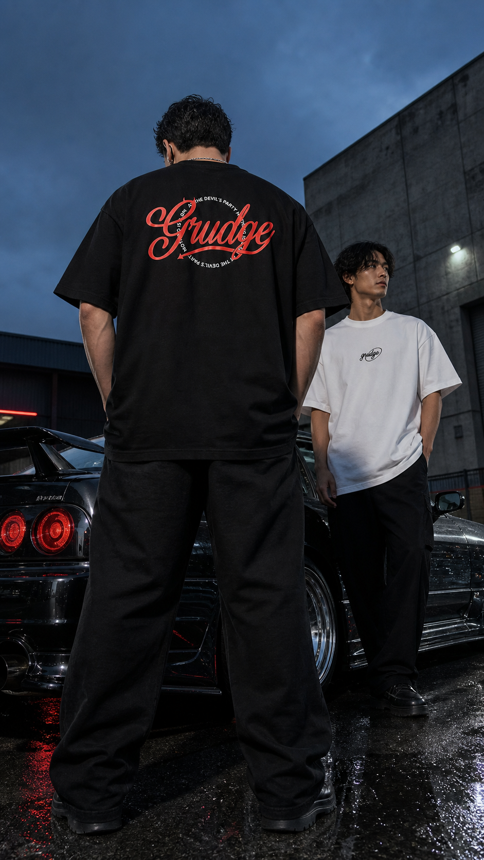 Low-angle view of the Grudge rear graphic beside a Japanese sports car